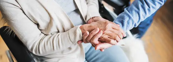 man holding elderly woman's hands