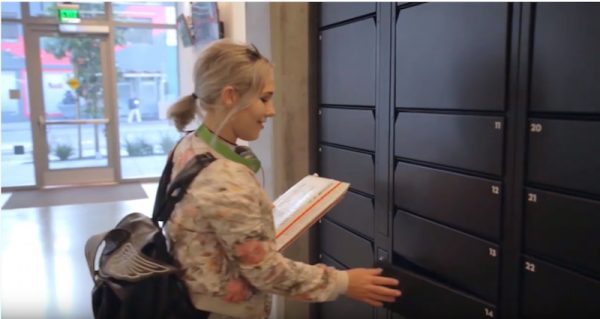 Woman picking up a small package from a smart parcel locker