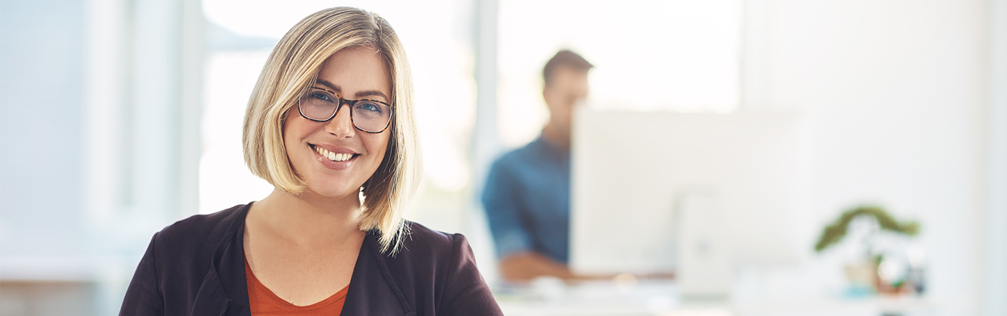 Tipps und Tricks für den Paketversand Lächelnde Frau am Arbeitsplatz