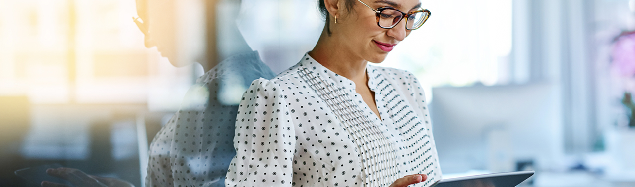 Woman wearing glasses looking at tablet