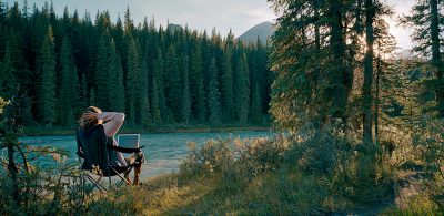 person in the wilderness looking at their laptop