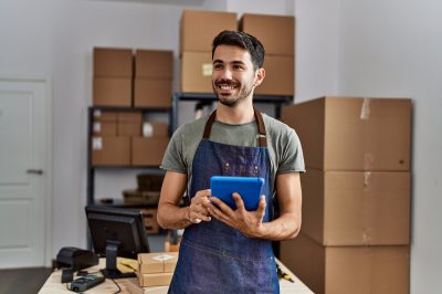 An young business worker using touchpad at storehouse