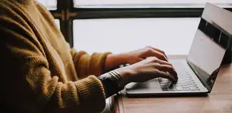 person at a desk typing on a laptop