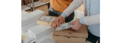 person adding shipping label to a package