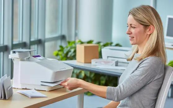 woman using a Pitney Bowes postage meter