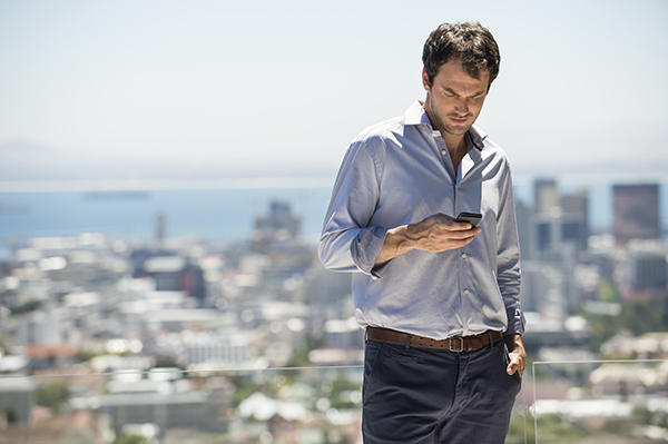 man above a city looking at his phone