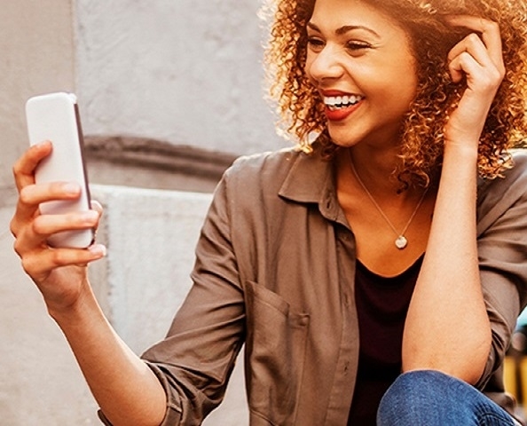 girl looking at her cell phone smiling