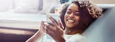 woman looking at her phone screen in a home office