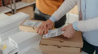 person adding shipping label to a package