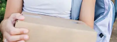 college student carrying a package